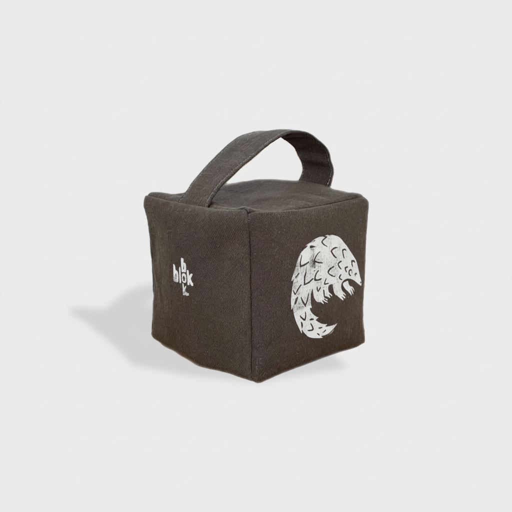 Charcoal Rolo pangolin doorstop with white ink - angled view